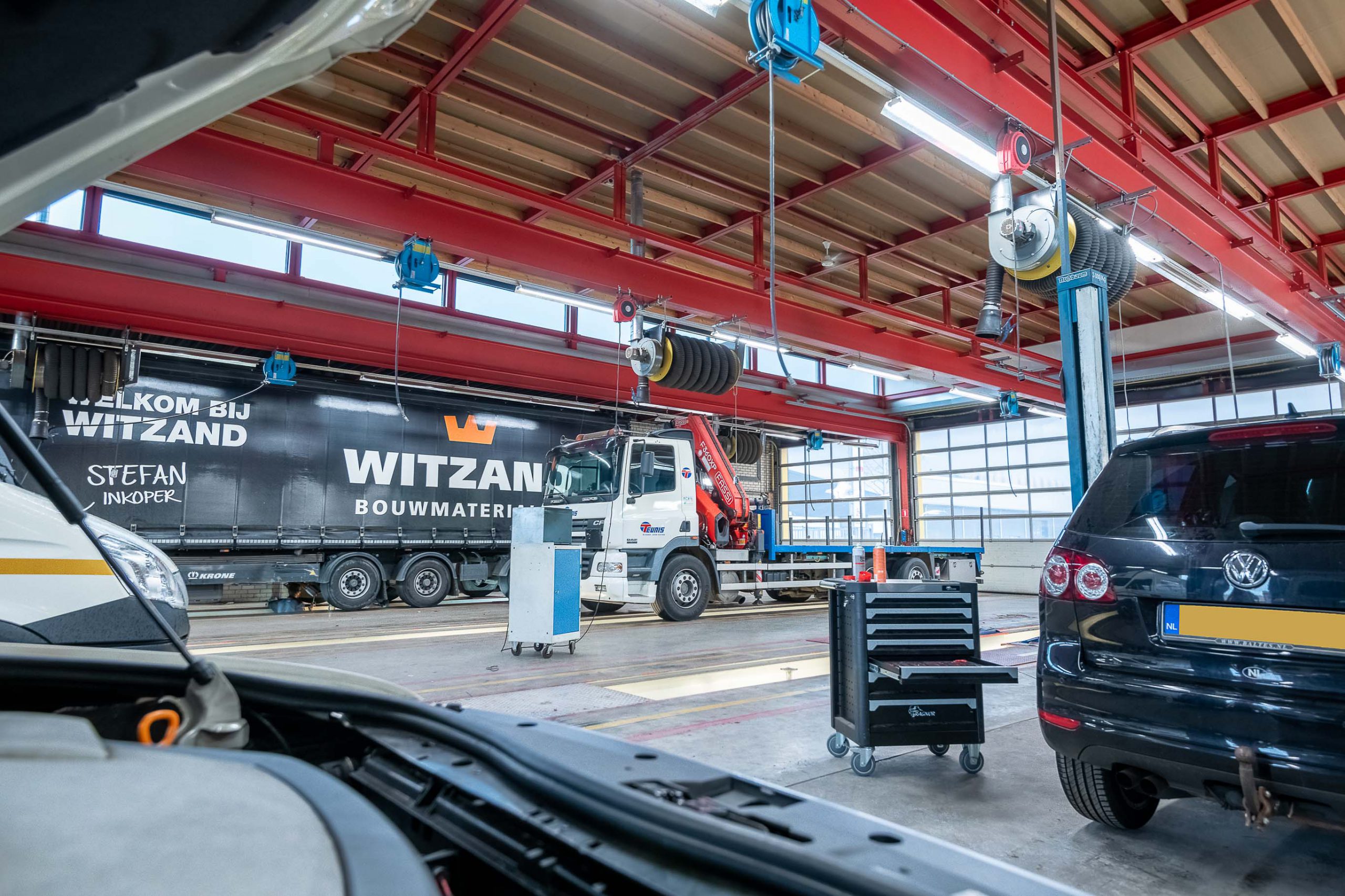 werkplaats met auto's vrachtwagens en werkbussen